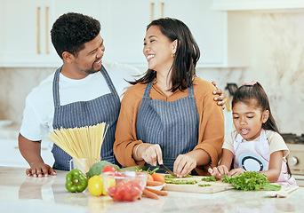 Image showing Cooking, kitchen and family with a girl, mother and father preparing food for a meal in their home together. Children, health and diet with a man, woman and daughter making dinner in a house