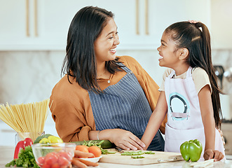 Image showing Happy family, mother girl cooking food for a healthy vegan diet with spaghetti and vegetables at home. Smile, development and child loves helping mom or mama in the house kitchen with lunch or dinner