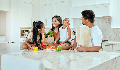 Image showing Asian, family and vegetables in kitchen for laugh at table, happy or comic in bonding. Mom, dad and children with smile at counter for funny, joke or crazy with bags after shopping in home in Jakarta