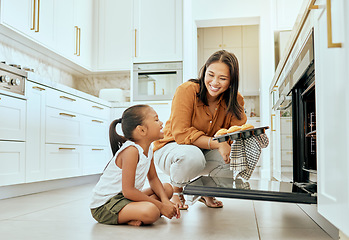 Image showing Asian, mom and girl in kitchen at oven, baking and cupcakes with stove, happy and home. Mother, child and muffins for learning, education and cooking in house for skills, love or bonding in Jakarta