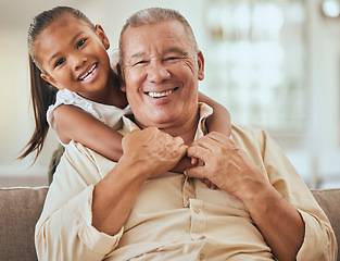 Image showing Grandfather, child and portrait with hug in home lounge to bond with young and cute grandchild. Family, elderly and senior grandpa in Indonesia holding kid with happy smile on sofa in house.