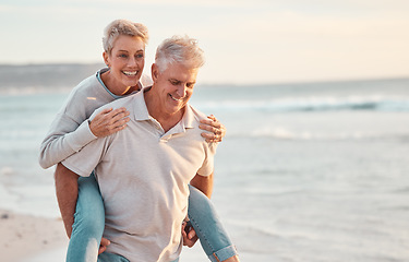 Image showing Love, beach and piggyback with a senior couple walking by the sea or ocean while on a date in summer together. Nature, earth and water with an elderly man and woman pensioner taking a walk on a coast