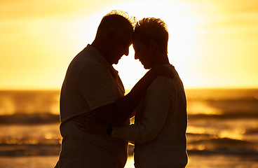 Image showing Couple, elderly and silhouette at beach with hug in sunset, evening or dusk by water, waves or horizon together. Senior, man and woman by ocean, sea or sunshine for care, affection or love in romance