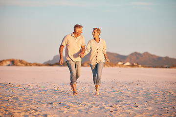 Image showing Senior couple on beach, hand holding during retirement and travel, holiday together with love and care outdoor. Elderly, man and woman, romantic walk on the sand, blue sky and summer vacation.