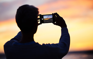 Image showing Man silhouette, smartphone and beach sunset photograph for social media post. Young photographer man, vacation travel adventure or holiday freedom trip by ocean sea memory on mobile technology app