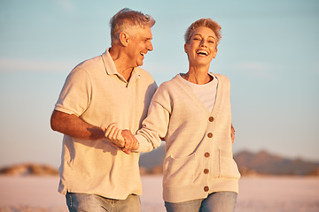 Image showing Retirement, couple and being playful outdoor, walking or on beach being loving, together or happy marriage. Love, senior man and mature woman with smile, embrace and holding hands and seaside bonding