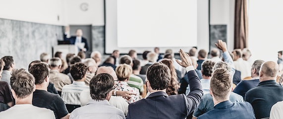 Image showing I have a question. Group of business people sitting in conference hall. Businessman raising his arm. Conference and Presentation. Business and Entrepreneurship