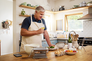 Image showing Wine, cooking and senior man in the kitchen preparing a meal for dinner or lunch at his home. Happy, retirement and elderly guy drinking an alcohol beverage with food to cook for a date at his house.