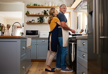 Image showing Senior couple in kitchen hug, cooking healthy food together and care in retirement lifestyle. Elderly man and woman with apron, hugging wife in home or love dinner meal with happy smile in marriage