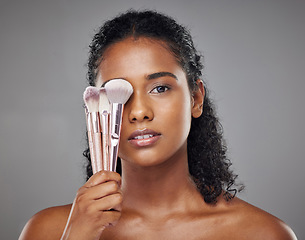 Image showing Beauty, black woman and portrait with brush cover on face for cosmetic powder or foundation tools. Makeup, cosmetics and brushes for beautiful girl model with grey studio mockup for marketing.
