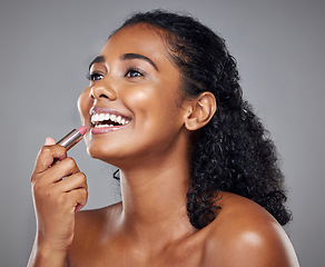 Image showing Lipstick, makeup and black woman with smile, thinking and idea against a grey studio background. Happy, young and African model with cosmetics, facial care and dermatology for beauty with a glow