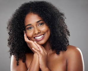 Image showing Black woman, beauty and hand on face, portrait and isolated on gray studio background. Makeup, cosmetics and female model from South Africa with healthy, beautiful and flawless skin or natural hair.