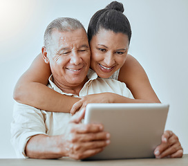 Image showing Tablet, internet and love with a senior couple browsing online using wireless technology in the home together. Relationship, smile and happy with an elderly male and female pensioner surfing the web