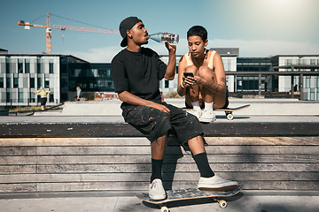 Image showing Skateboard, drinking water and friends with a black man and woman skater outdoor in a city for fun or recreation together. Couple, skating and summer with a male and female in an urban town to skate