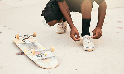 Image showing Skater, shoes and tie laces with skateboard in park for safety, exercise and skating outdoor in city. Man, sneakers and shoelaces on feet, ground and skatepark in summer for fitness, sport and fun
