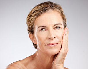 Image showing Face, beauty and antiaging with a mature woman in studio on a gray background for skincare or wellness. Cosmetics, health and treatment with a senior female posing to promote a natural product