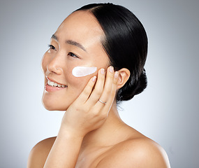 Image showing Beauty, face and skincare cream with woman in a studio for facial, cleaning and grooming with mockup. Skin, sunscreen and asian model relax with wellness product, cosmetics and face cream treatment