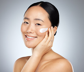 Image showing Woman, face cream or grooming skincare routine on studio background for Japanese facial, wellness or luxury healthcare. Zoom, smile or happy beauty model with spf sunscreen product for sun protection