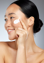 Image showing Korean skincare, happy and face skin cream of a woman with a smile using lotion. Happiness of a person from Korea smiling about facial wellness, beauty cosmetic care and dermatology serum moisturizer