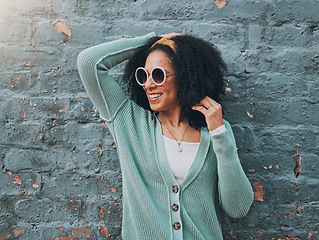 Image showing Brazilian woman, fashion and sunglasses by city building wall for fun summer holiday, weekend break or urban vacation. Smile, happy student or afro tourist in trendy, cool clothes and style eye care