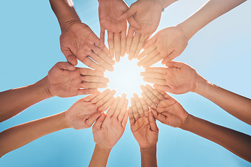 Image showing Hands in circle together, blue sky and sun, diversity and community in collaboration for support and success. Teamwork, hands together and summer sunshine, positive vision and trust between friends.