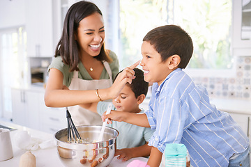 Image showing Family baking and mother teaching children to bake cake in the kitchen of their home. Happy latino kids and woman play, cooking and laugh together while learning about food and being playful in home