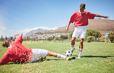 Image showing Men, soccer and slide tackle in sports fitness, training and exercise on the field outdoors. Athletic man tackling football player in sport for control, possession or defense in game or match outside