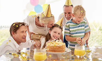 Image showing Girl, birthday cake and family celebrating a children event with food and a party outdoor. Happy smile of kids, father and mom kiss to celebrate youth and kid event with happiness, love and confetti