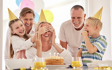 Image showing Surprise, mother birthday and family celebrate at a party at home with a happy smile. Mama, father and children with happiness and excited joy in a house with event food, cake and candles for mom
