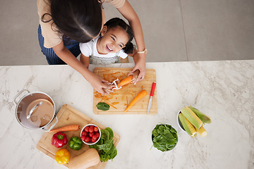 Image showing Development, child and mother in kitchen, vegetables and learn cooking together being happy, smile and safety. Top view, mama and girl peeling food, childcare and cutting veggies and organic dinner.