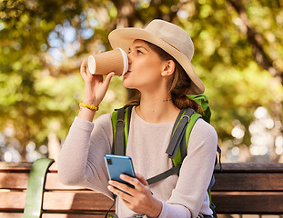 Image showing Woman, phone and coffee in relax for backpacking on park bench for nature adventure in the outdoors. Female hiker or explorer relaxing on smartphone and drinking beverage with 5G connection for GPS