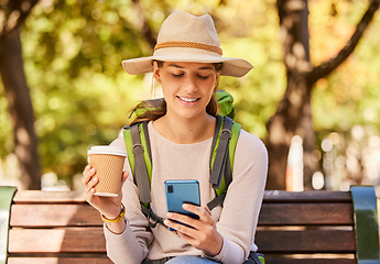 Image showing Woman, phone and travel with coffee for backpacking in nature adventure relaxing on a park bench in the outdoors. Happy female traveler in social media, browsing or texting for trip on smartphone