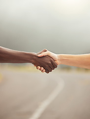 Image showing Handshake, success and hands with diversity, support and teamwork partnership on a road. Hand together of friends, workers or people showing motivation solidarity, faith trust and hope outdoor