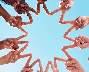 Image showing Peace star sign, people and hands of people together with diversity showing support and community. Below view of friends in the outdoor and blue sky show solidarity, friendship and collaboration