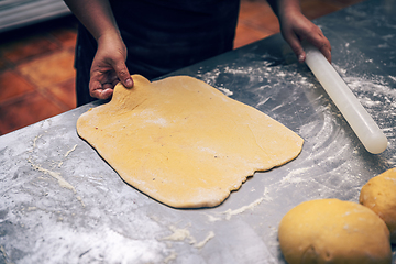 Image showing Woman's hands roll the dough