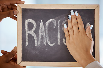 Image showing Racism, protest and stop hands on blackboard to remove inequality writing for a change in society. Race, prejudice and black lives matter group cleaning chalkboard to erase word of hate closeup.