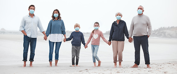 Image showing Covid, walking and family at the beach with face mask on, holding hands with grandparents, parents and children. Big family on a walk, stroll and relax by the ocean after covid 19 pandemic lockdown
