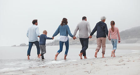 Image showing Love, walking and family holding hands on the beach, bond or enjoy fun quality time together on vacation back view. Support trust, peace and big family travel on Canada adventure holiday for freedom