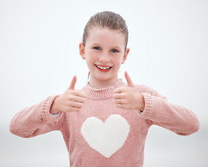 Image showing Happy, teenager girl and hands in thumbs up with smile for gesture, sign or symbol against a grey background. Portrait of female teen smiling with hand for okay, yes or great emoji in happiness