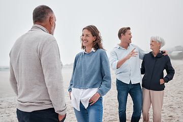 Image showing Family bonding, beach and outdoor conversation of people happy spending time together. Communication of a woman, man and elderly parents on ocean sand on a cloudy day on vacation with happiness