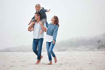 Image showing Family, children and beach with a mother, father and boy walking on the sand while on holiday or vacation. Nature, summer and travel with a man, woman and boy child taking walk together on the coast