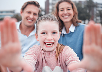 Image showing Girl, hand frame and family for selfie with smile, portrait or happy in city, metro or town at park, comic or bonding. Mother, father or kid with parents, laugh or funny in photo, outdoor or together