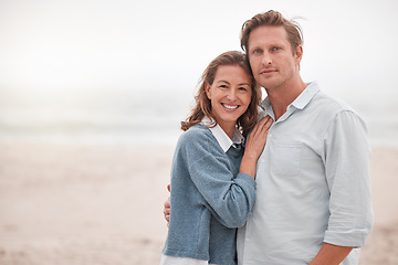 Image showing Happy, couple and portrait smile on a beach together relaxing while enjoying quality bonding time in the outdoors. Man and woman smiling in happiness for hug, relationship love or care on sandy ocean