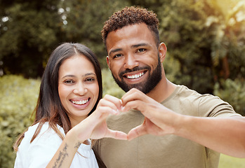 Image showing Couple, happy and hand heart sign in a nature park showing love and a smile outdoor. Black people with happiness and care putting hands together to show solidarity, trust and romantic commitment