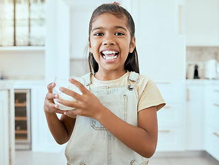 Image showing Milk, portrait and child with a healthy drink for energy, growth and nutrition in the kitchen of a house. Happy, young and girl with a smile for calcium in a glass for breakfast and care for teeth