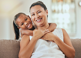 Image showing Love, hug and grandmother portrait with granddaughter bonding at home on the living room sofa. Mature woman embracing and hugging or cuddling with her little grandkid for relaxing care and bond