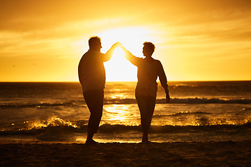 Image showing Love, ocean and sunset, silhouette of couple on beach holding hands in Bali. Waves, romance and man and woman dancing in evening sun on romantic vacation spending time together in nature and sea sand