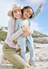 Image showing Love, mother and girl on beach, bonding and relax for holiday vacation and outdoor together. Mama, daughter and happy kid with smile, embrace and hug on seaside sand, in summer and adventure travel.