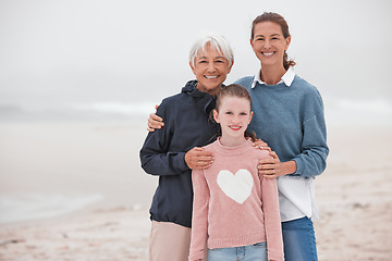 Image showing Mother, grandma and child at beach in portrait, bonding or love in winter, mist or cloud by sea. Mom, girl and senior for smile, happy or care in family, happiness or together at ocean on vacation