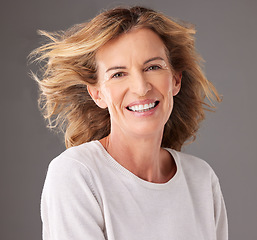 Image showing Skincare, beauty and portrait of happy old woman, smile on face and hair blowing. Wellness, beauty products and confident senior female pose for anti aging cosmetics and dermatology care in studio